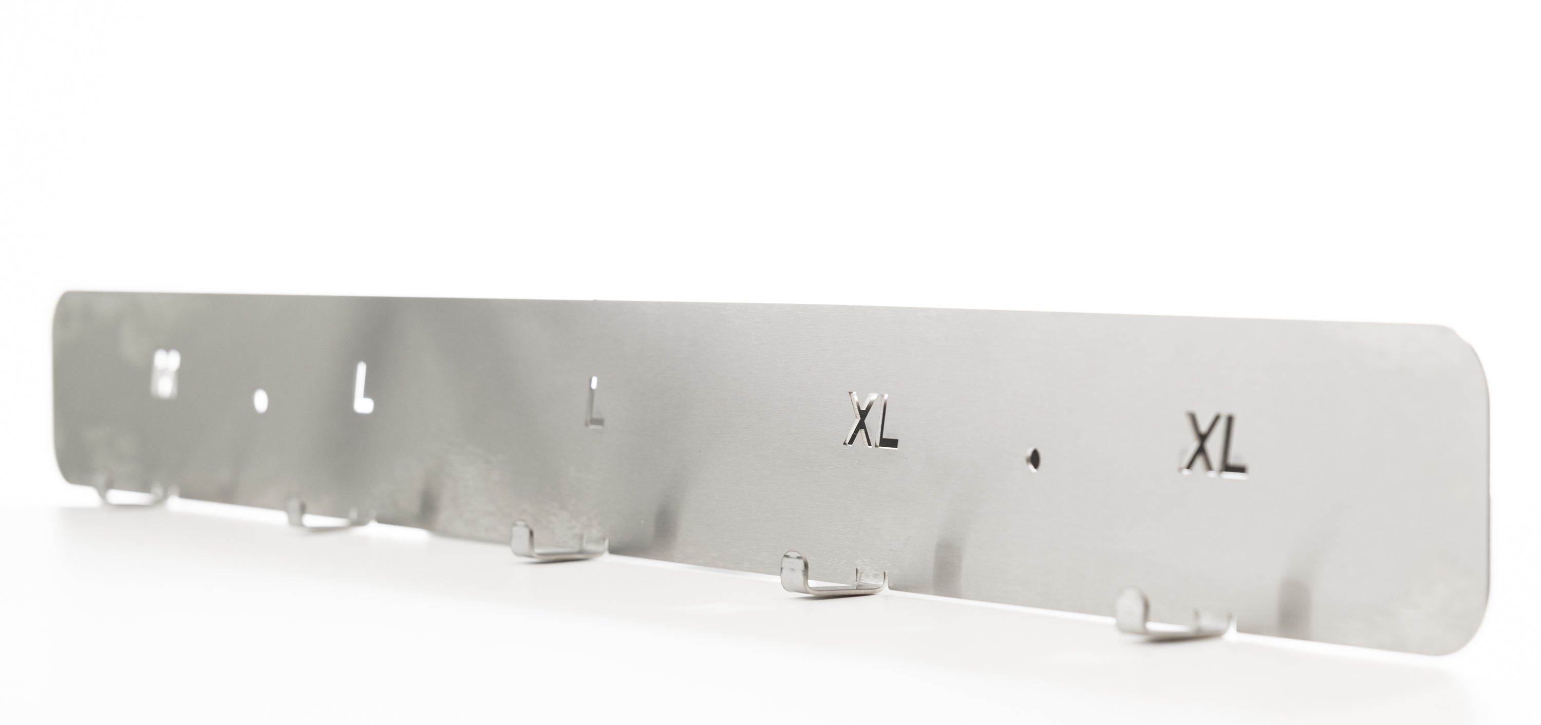 Metallic clothing size chart with 'S', 'M', 'L', 'XL' The TLC Hi Viz Holder 5 Hangers keeps high visibility vests organized, accessible, and easily identifiable in Lean workplaces. It provides a dedicated storage solution for shared PPE in factories, warehouses, workshops, and site offices. This holder helps reduce clutter, prevent loss, and supports 5S and 6S safety standards. Ideal for entrances, locker areas, and workstations.